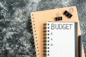 Top view budget written note on notepad with pen on dark background