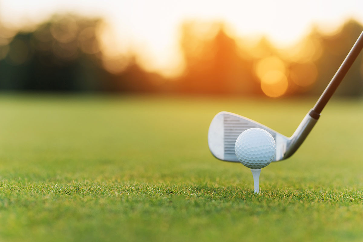 Golf Ball on Tee Playing Sports on Green Fairway.